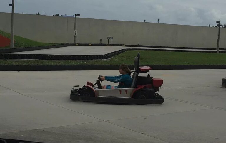 A student races a go-kart around an outdoor track