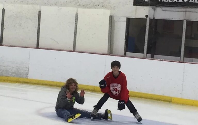 Students skate on an indoor ice rink